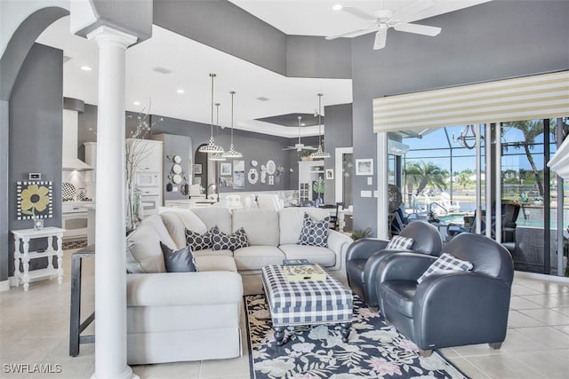 tiled living room featuring ornate columns and ceiling fan