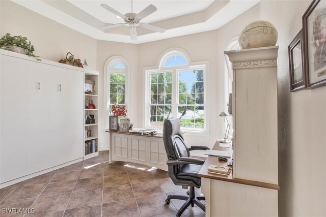 office space featuring a raised ceiling and ceiling fan