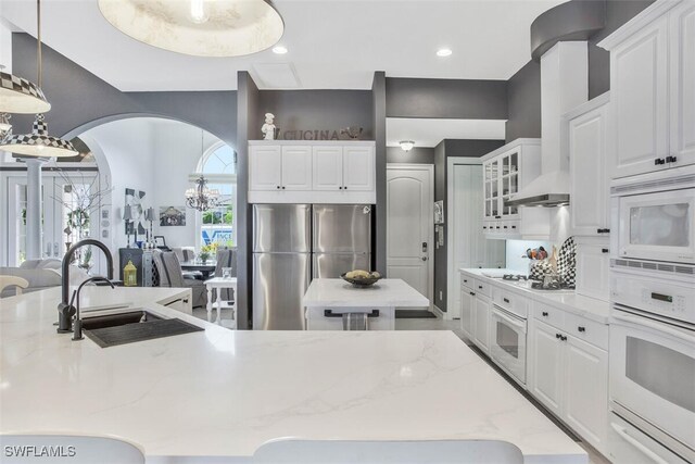 kitchen with white appliances, sink, and white cabinets