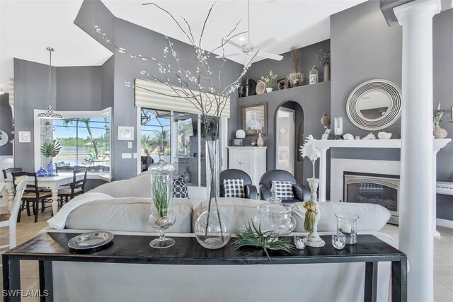 living room featuring a tile fireplace and high vaulted ceiling