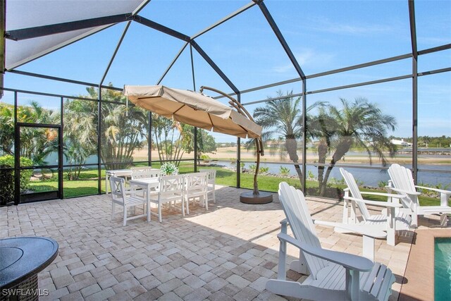 view of patio / terrace with a water view and glass enclosure