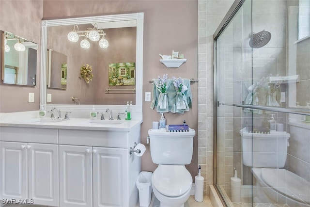 bathroom with vanity, a shower with door, and toilet