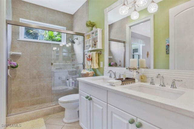 bathroom featuring vanity, tile patterned flooring, a shower with door, and toilet