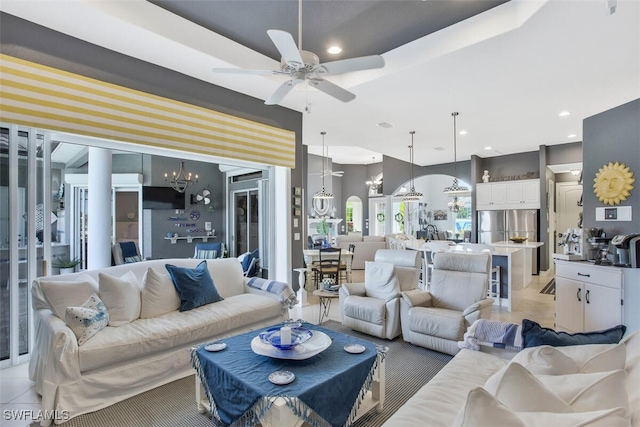 living room with ceiling fan with notable chandelier and light tile patterned flooring