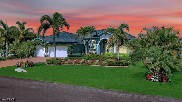 view of front of property with a yard and a garage