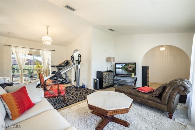 living room featuring lofted ceiling and an inviting chandelier