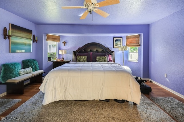 bedroom with multiple windows, a textured ceiling, ceiling fan, and dark wood-type flooring