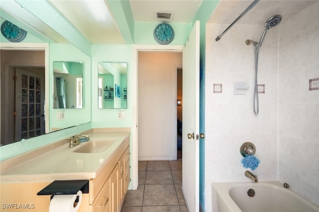 bathroom featuring tile patterned flooring, tiled shower / bath combo, and vanity