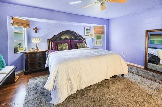 bedroom with ceiling fan, dark hardwood / wood-style flooring, and a textured ceiling