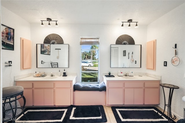 bathroom featuring vanity, a textured ceiling, track lighting, and tile patterned floors