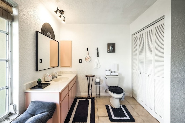 bathroom featuring tile patterned flooring, vanity, a textured ceiling, and toilet