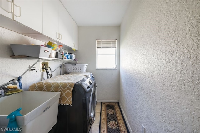 washroom featuring washing machine and clothes dryer, sink, cabinets, and tile patterned flooring