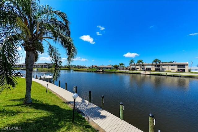 view of dock featuring a water view and a yard