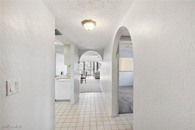 hallway featuring a textured ceiling and light tile patterned flooring