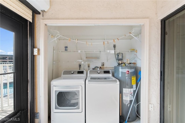 washroom with electric water heater and washing machine and clothes dryer