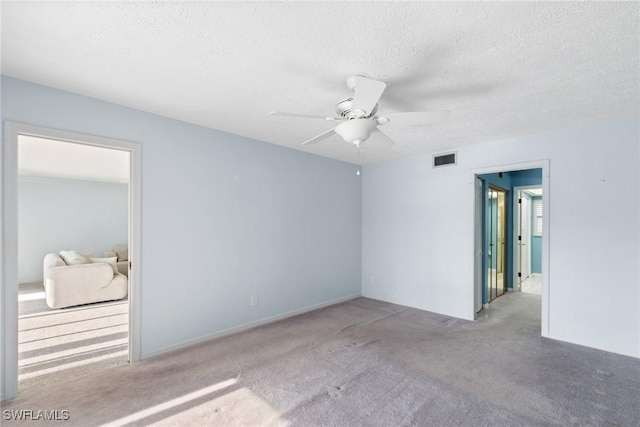 carpeted empty room featuring ceiling fan and a textured ceiling