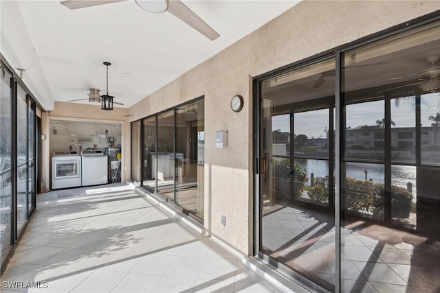 exterior space featuring ceiling fan, a water view, and washer and clothes dryer