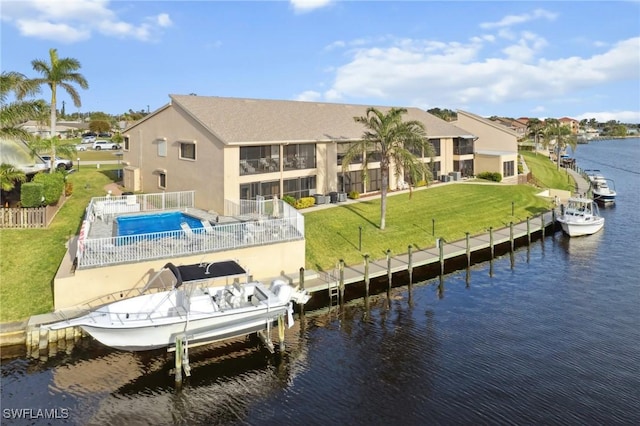 back of property featuring a water view and a lawn