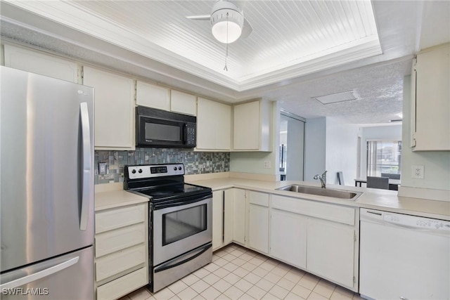 kitchen featuring appliances with stainless steel finishes, tasteful backsplash, sink, white cabinets, and light tile patterned floors