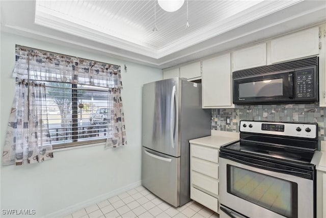 kitchen featuring a raised ceiling, white cabinetry, decorative backsplash, stainless steel appliances, and crown molding