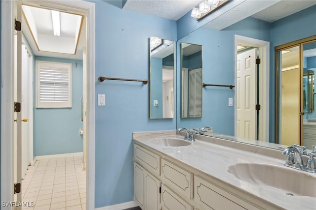 bathroom featuring tile patterned flooring, vanity, and a textured ceiling