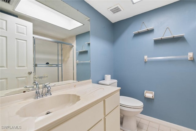 bathroom with toilet, vanity, a shower with door, and tile patterned flooring