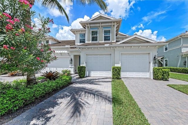 2319 Sawyers Hill Rd Unit 708, Naples, FL 34120 - view of front of home with an attached garage, stucco siding, and decorative driveway