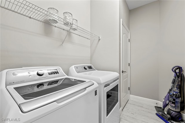 laundry room with washer and dryer and light hardwood / wood-style floors