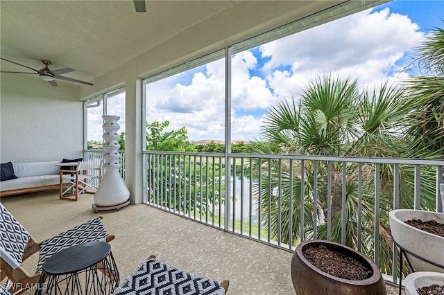 sunroom / solarium with a water view and ceiling fan