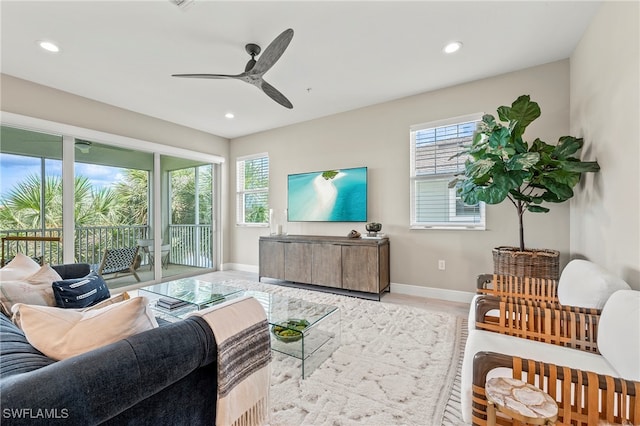 living room with light wood-type flooring, plenty of natural light, and ceiling fan