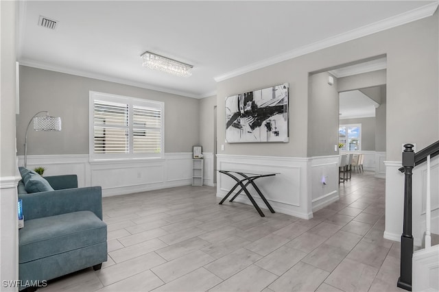 living area with plenty of natural light and ornamental molding