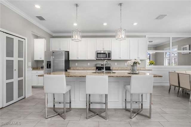 kitchen featuring sink, light stone counters, a breakfast bar area, a kitchen island with sink, and appliances with stainless steel finishes