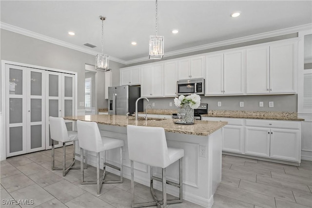 17641 Brooksin Ct, Estero, FL 33928 - kitchen featuring white cabinets, hanging light fixtures, an island with sink, and stainless steel appliances