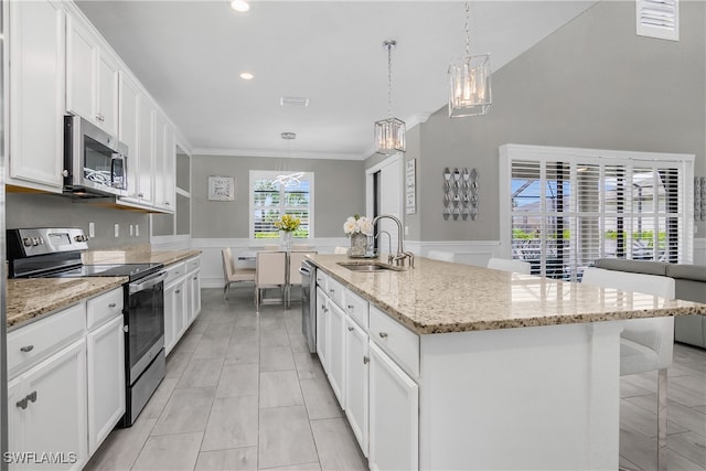 kitchen featuring white cabinetry, sink, hanging light fixtures, a kitchen island with sink, and appliances with stainless steel finishes