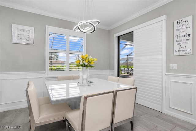 dining space with ornamental molding and a notable chandelier