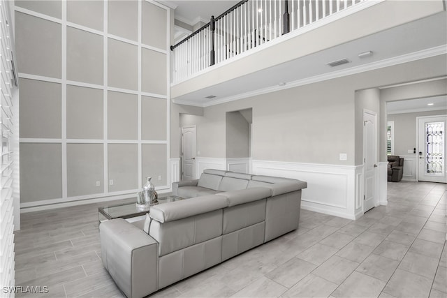 living room with a towering ceiling and ornamental molding