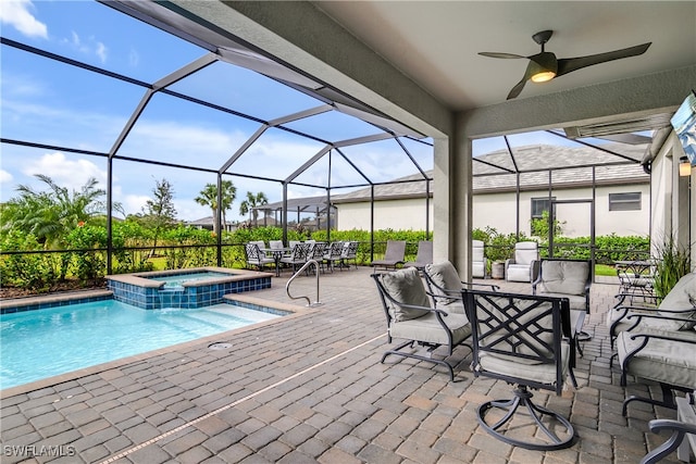 view of swimming pool featuring glass enclosure, ceiling fan, a patio, and an outdoor hangout area