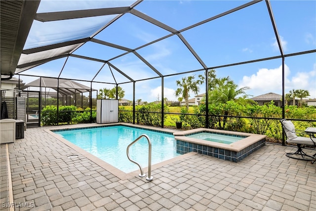 view of pool featuring glass enclosure, an in ground hot tub, and a patio area