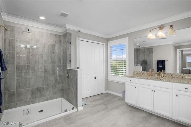 bathroom featuring a shower with door, vanity, and ornamental molding