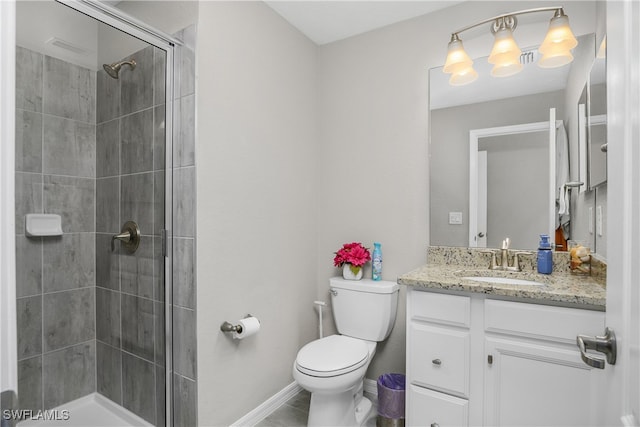 bathroom with a tile shower, vanity, and toilet