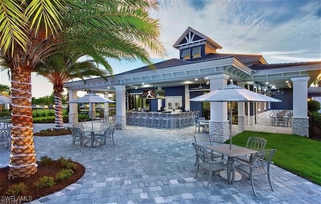 patio terrace at dusk featuring a bar and a gazebo