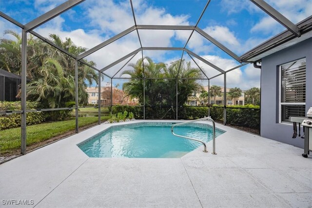 view of swimming pool with a patio area and glass enclosure