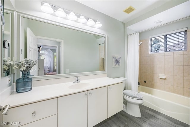 full bathroom featuring toilet, vanity, hardwood / wood-style flooring, and shower / tub combo with curtain