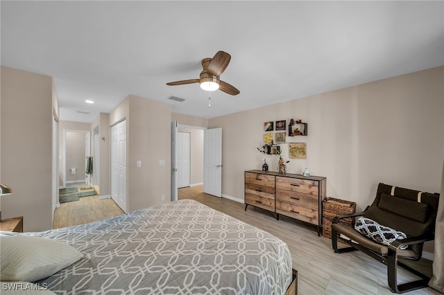 bedroom with a closet, hardwood / wood-style flooring, ensuite bathroom, and ceiling fan