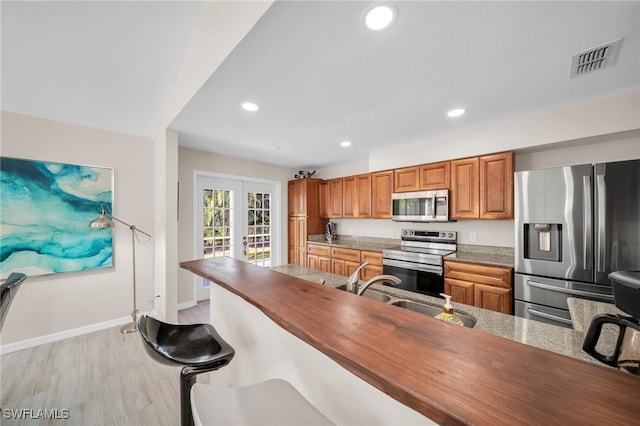 kitchen featuring sink, appliances with stainless steel finishes, and light hardwood / wood-style floors