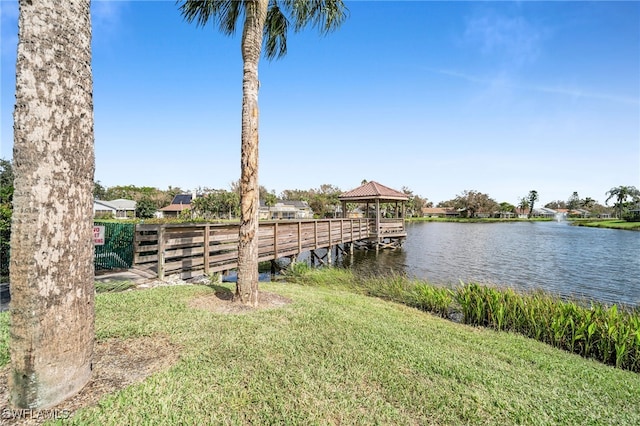 view of dock featuring a water view, a gazebo, and a lawn