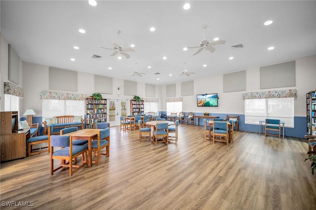 interior space featuring wood finished floors, visible vents, recessed lighting, and a high ceiling