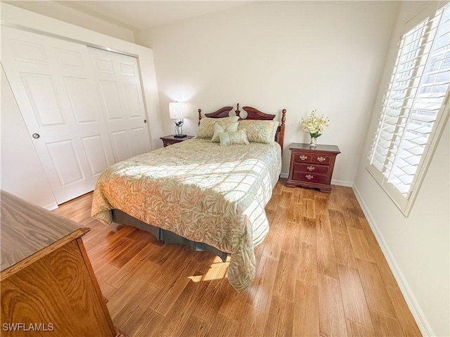 bedroom with light hardwood / wood-style flooring and a closet