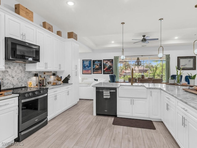 kitchen featuring sink, white cabinets, decorative light fixtures, appliances with stainless steel finishes, and light stone counters