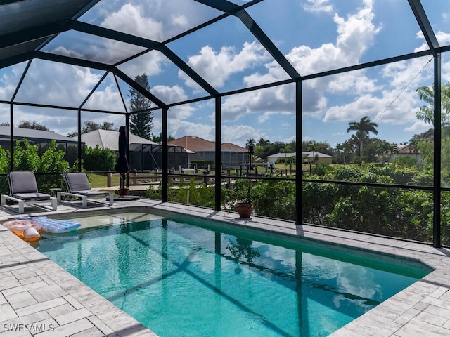 view of pool with a patio area and glass enclosure